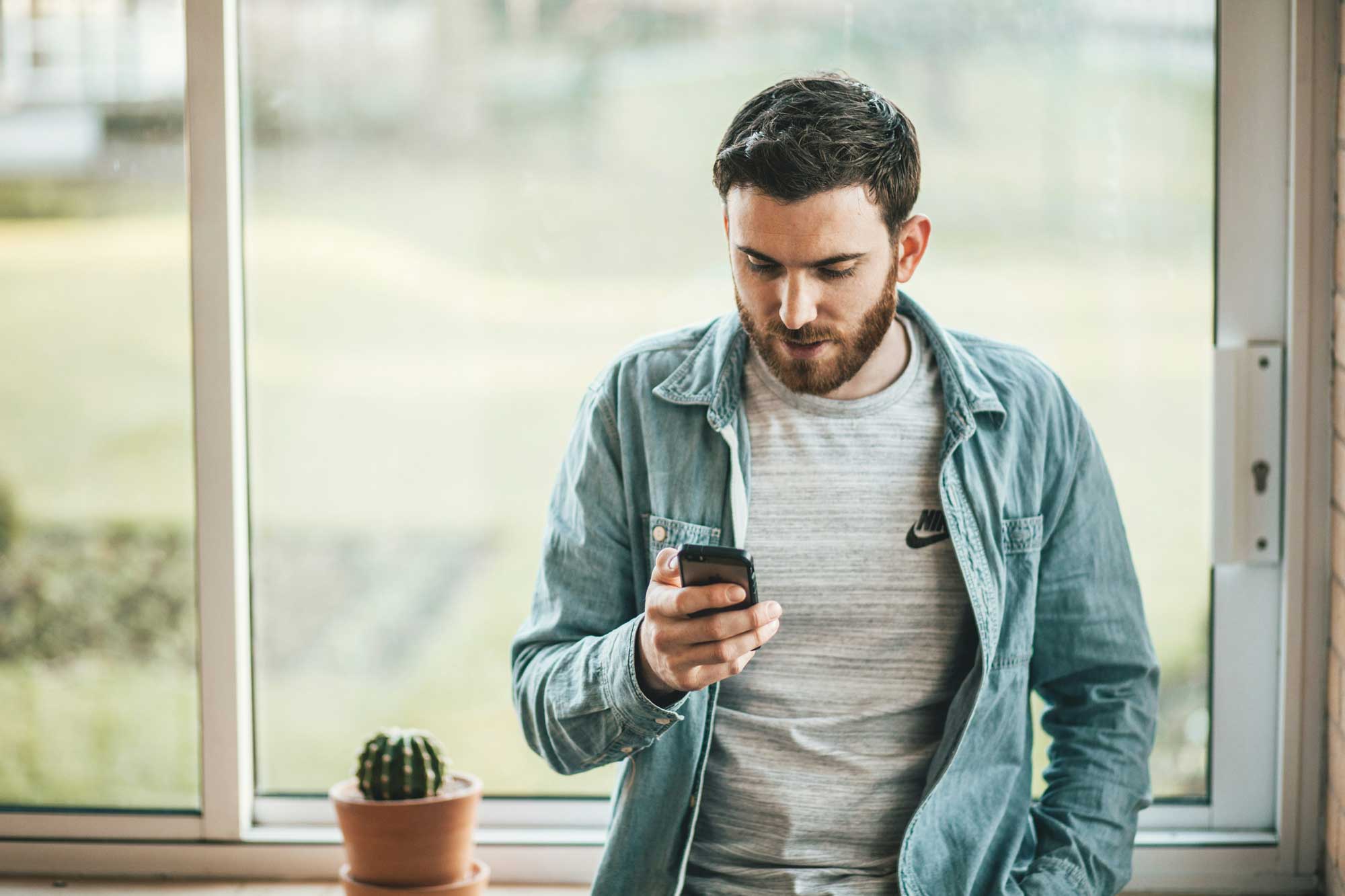 Man twijfelt met telefoon in zijn hand